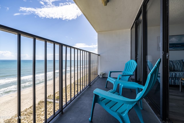 balcony with a water view and a beach view