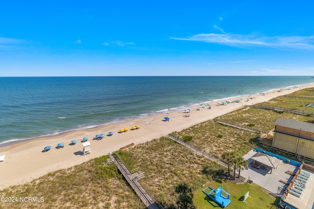 birds eye view of property featuring a water view and a beach view