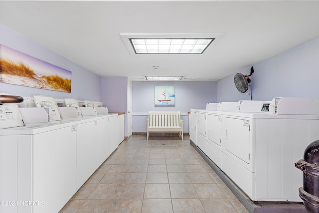 shared laundry area with light tile patterned floors and independent washer and dryer