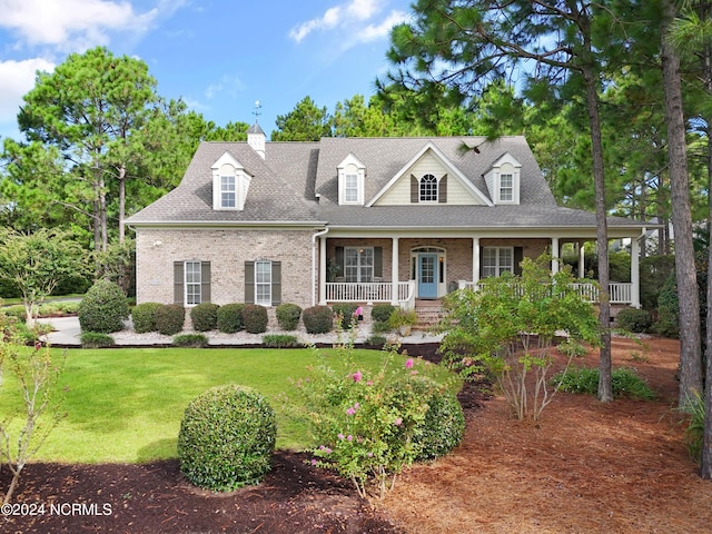 new england style home with a front yard and a porch