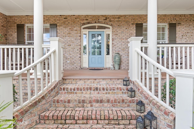 view of exterior entry featuring covered porch