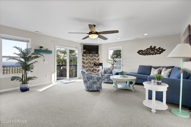 living room with ceiling fan, carpet floors, and a healthy amount of sunlight