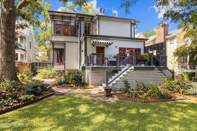 rear view of property with stairs, a yard, and fence