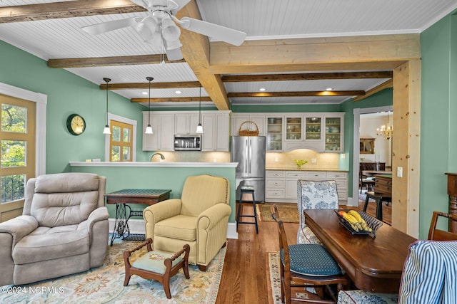 living area with recessed lighting, beamed ceiling, wood finished floors, and ceiling fan with notable chandelier