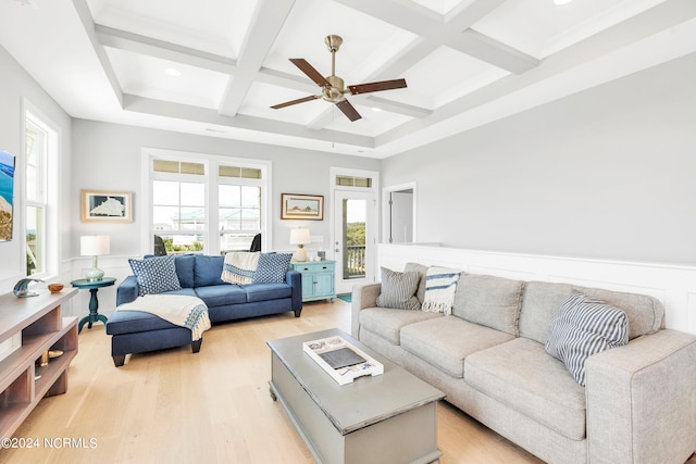 living room with ceiling fan, light wood-type flooring, beamed ceiling, and coffered ceiling