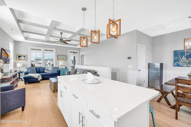 kitchen featuring white cabinets, hanging light fixtures, light hardwood / wood-style flooring, coffered ceiling, and a center island