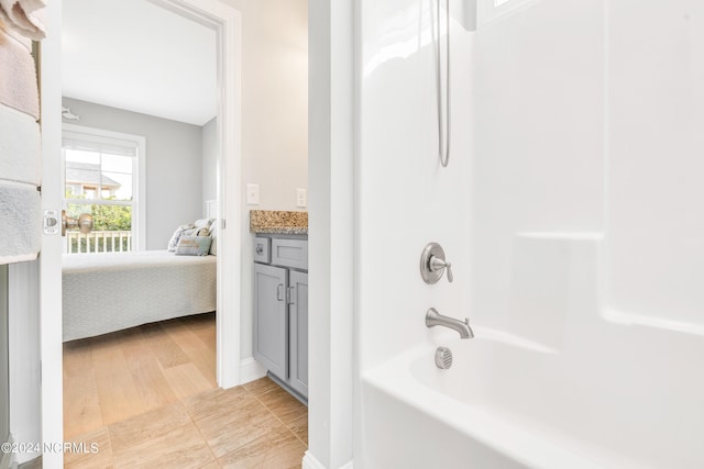 bathroom featuring  shower combination, vanity, and hardwood / wood-style floors