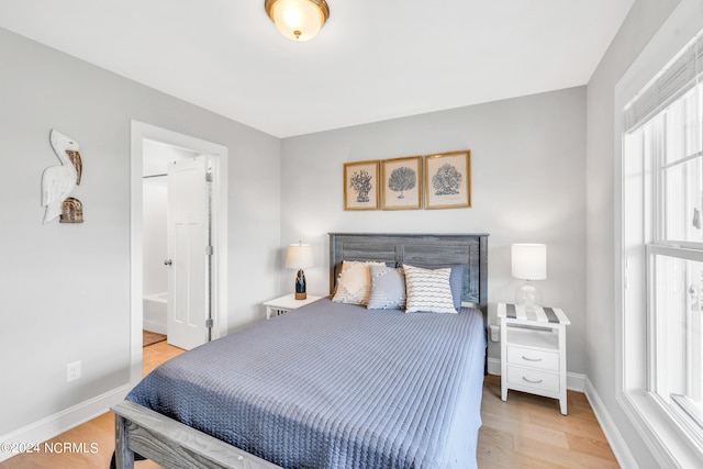 bedroom featuring light hardwood / wood-style floors and connected bathroom