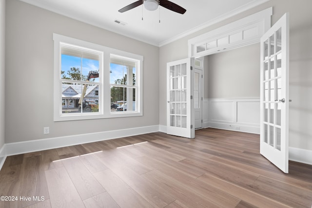 empty room featuring crown molding, french doors, ceiling fan, and hardwood / wood-style floors