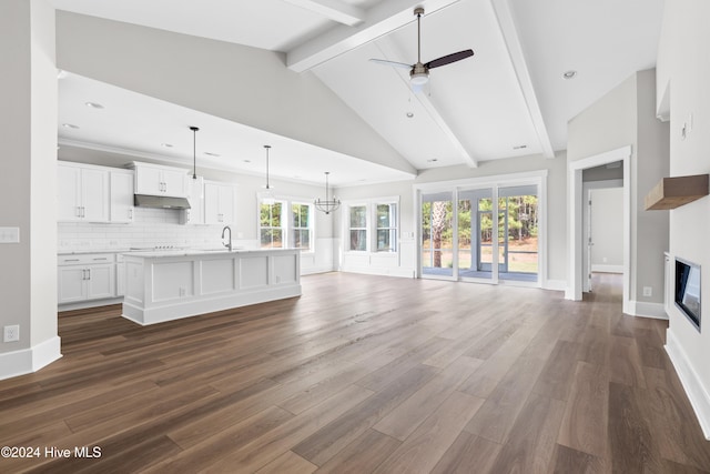 unfurnished living room with beam ceiling, sink, dark hardwood / wood-style flooring, high vaulted ceiling, and ceiling fan with notable chandelier