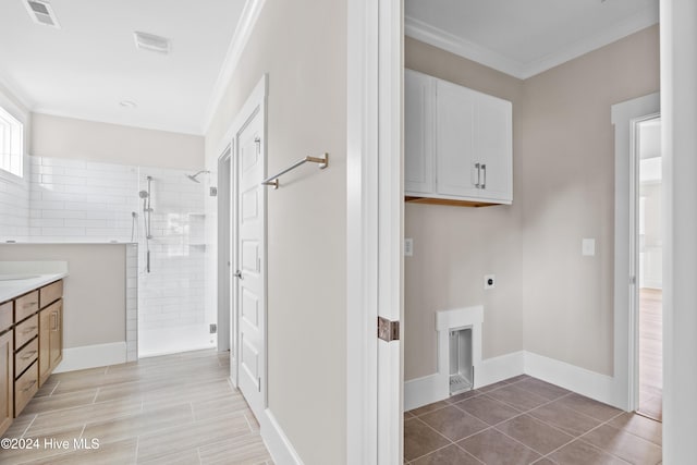 washroom featuring hookup for an electric dryer, cabinets, ornamental molding, and sink