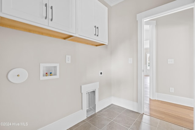 laundry area featuring cabinets, washer hookup, tile patterned flooring, and hookup for an electric dryer