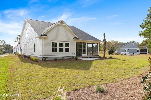 rear view of house with a lawn and a sunroom