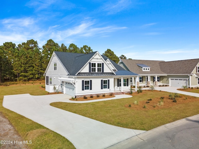 view of front of property featuring a garage, covered porch, and a front yard