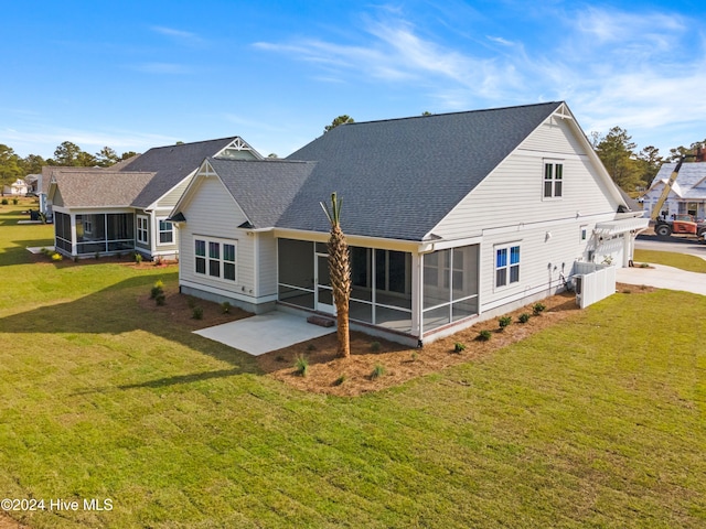 rear view of house with a patio, a lawn, and a sunroom