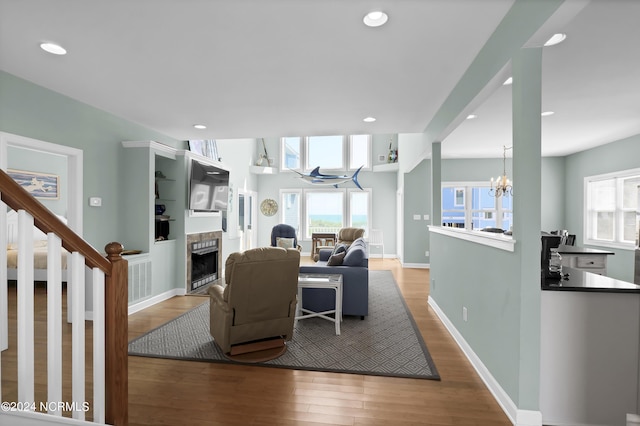 living area with plenty of natural light, a fireplace, wood finished floors, and baseboards