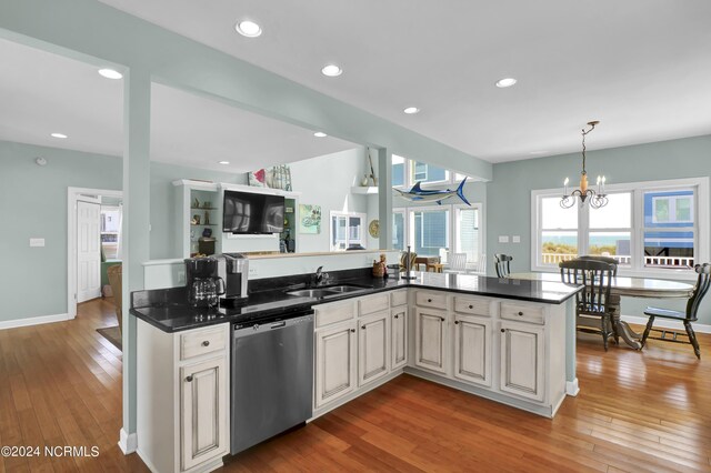 kitchen with hanging light fixtures, dishwasher, light wood-type flooring, a chandelier, and sink