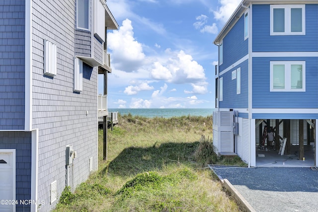 view of property exterior featuring a patio, a carport, and a water view