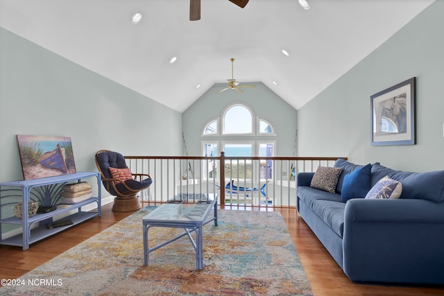 living room featuring lofted ceiling, hardwood / wood-style flooring, and ceiling fan