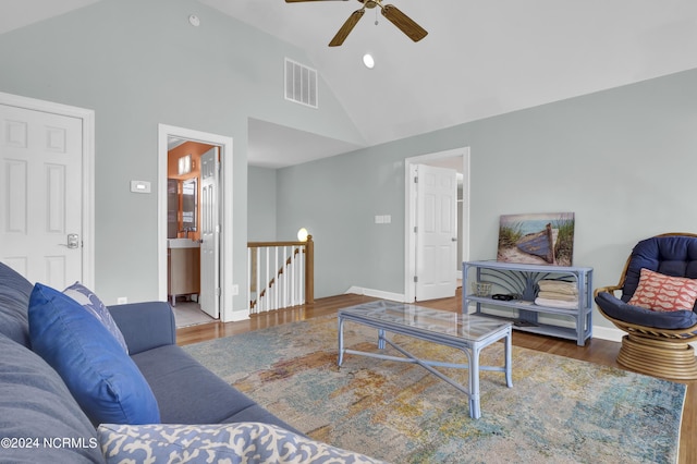 living room featuring high vaulted ceiling, visible vents, baseboards, and wood finished floors