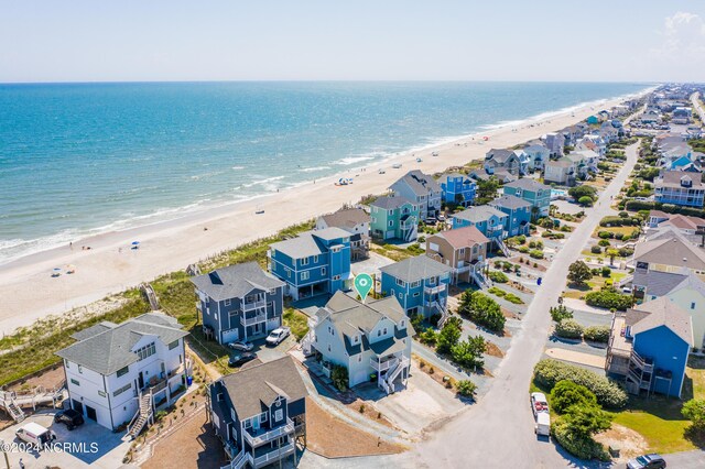 birds eye view of property with a water view and a view of the beach