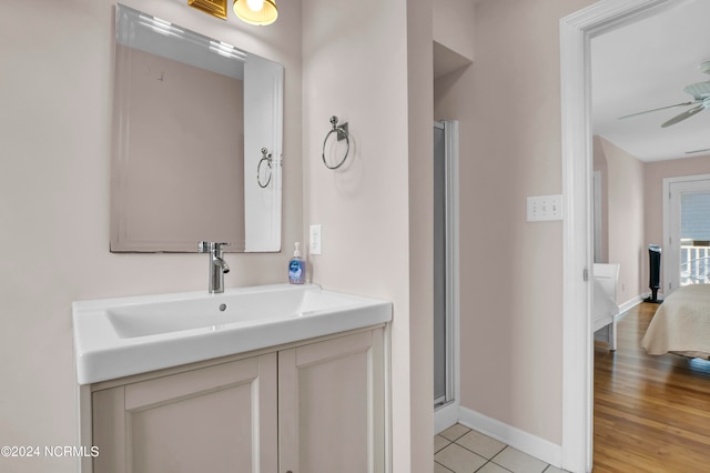 bathroom featuring vanity, hardwood / wood-style floors, an enclosed shower, and ceiling fan