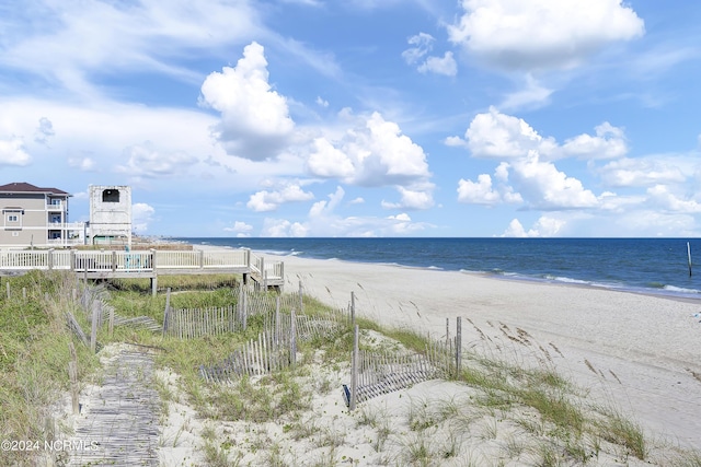 view of water feature featuring a beach view and fence