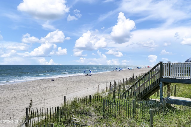 water view with fence and a view of the beach