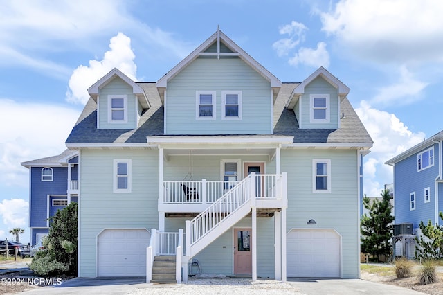 coastal inspired home with stairs, a porch, an attached garage, and cooling unit