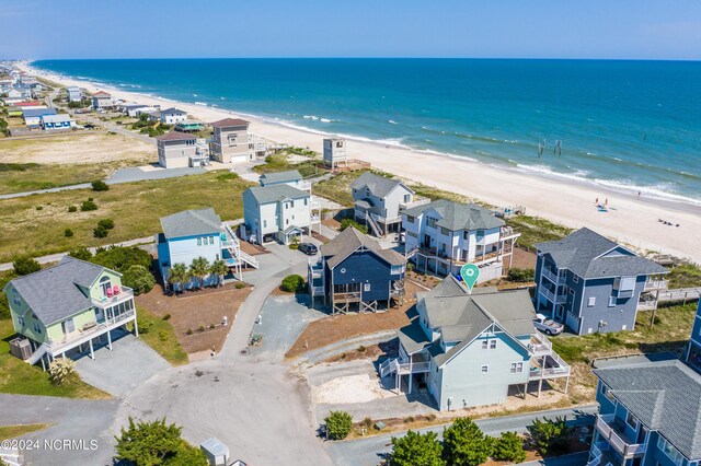 bird's eye view featuring a water view and a beach view