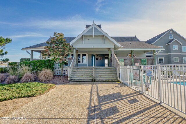 view of front of home with a community pool and a porch