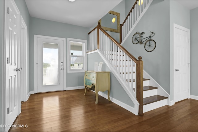 foyer entrance featuring wood-type flooring, baseboards, and stairs