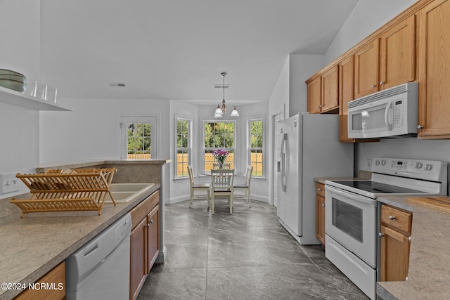 kitchen featuring a notable chandelier, white appliances, vaulted ceiling, and decorative light fixtures