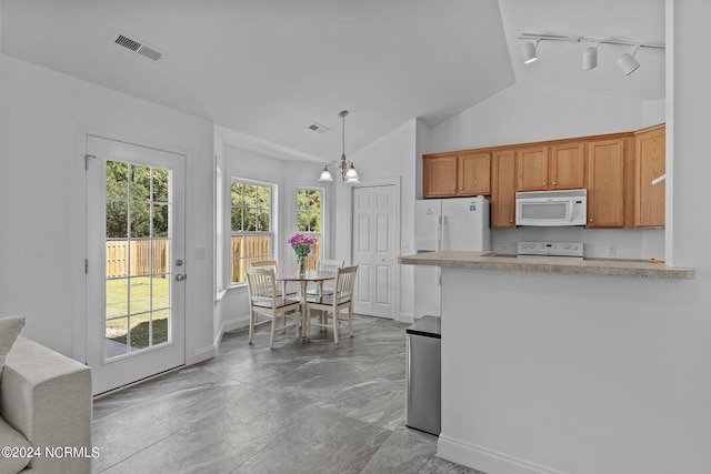 kitchen with white appliances, lofted ceiling, track lighting, decorative light fixtures, and a notable chandelier