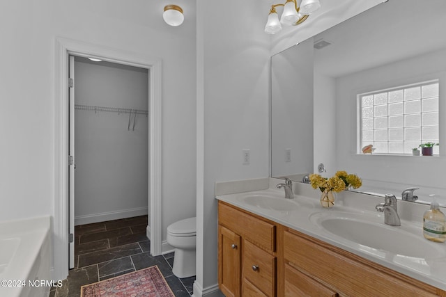 bathroom with vanity, a bathing tub, and toilet