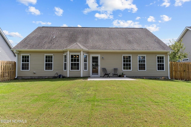 back of property with a lawn and a patio