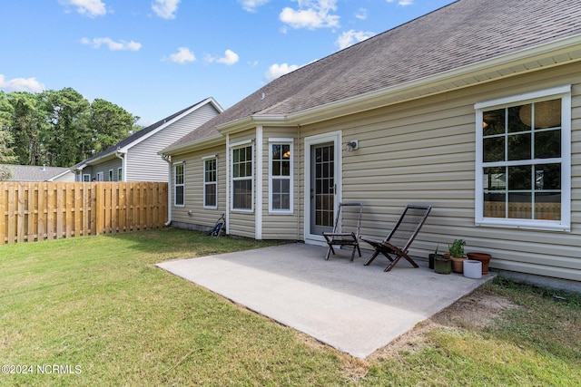 rear view of property featuring a yard and a patio area