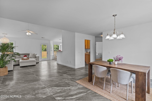 dining area featuring ceiling fan with notable chandelier