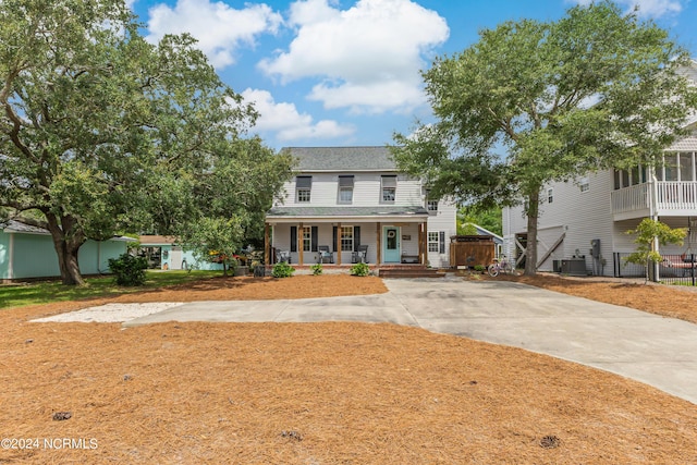 view of front of house with a porch, cooling unit, and roof with shingles