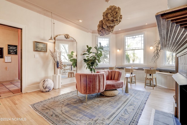 living area with crown molding and light hardwood / wood-style floors