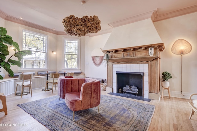 living room featuring wood-type flooring, a fireplace, and crown molding