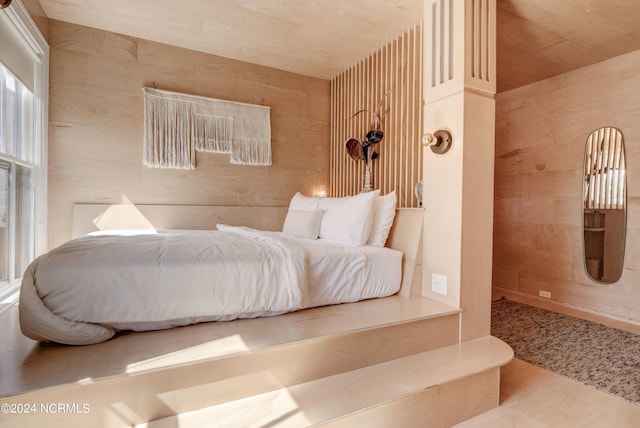 bedroom featuring wooden walls