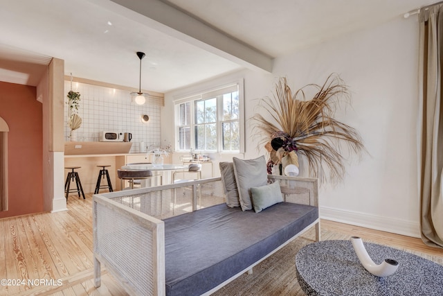 living area featuring hardwood / wood-style flooring and beam ceiling