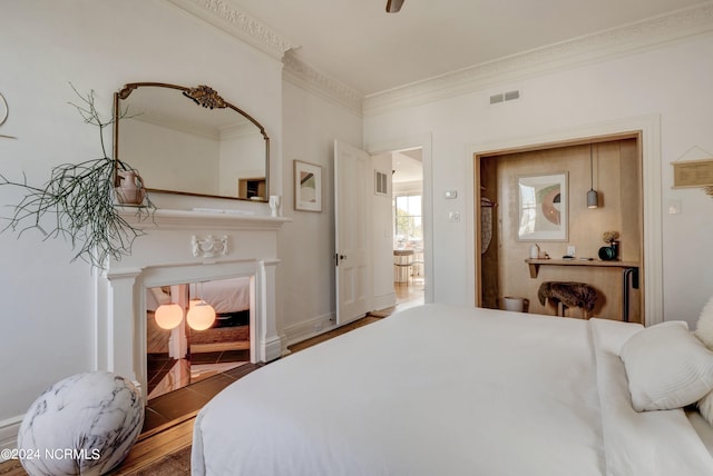 bedroom featuring ornamental molding and dark hardwood / wood-style flooring