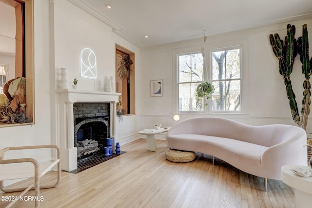 sitting room with hardwood / wood-style flooring and ornamental molding