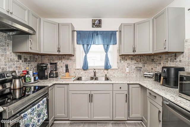 kitchen featuring sink, gray cabinets, appliances with stainless steel finishes, and decorative backsplash