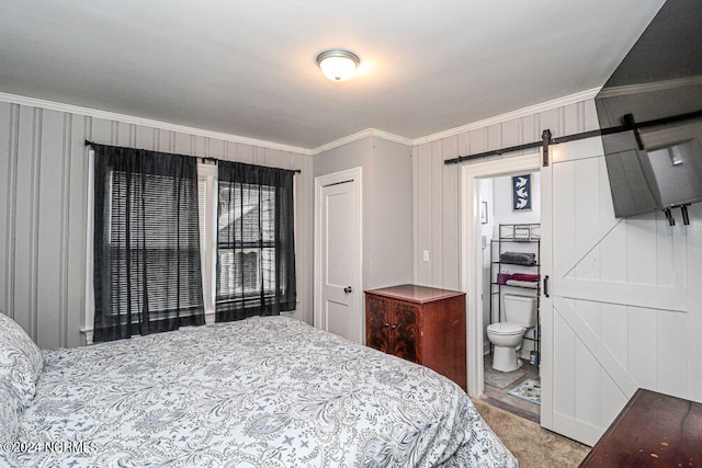 carpeted bedroom with ornamental molding, connected bathroom, and a barn door