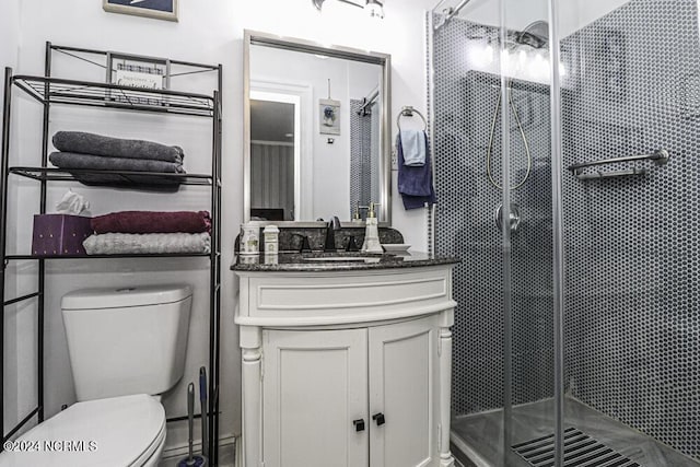 bathroom with a stall shower, vanity, and toilet