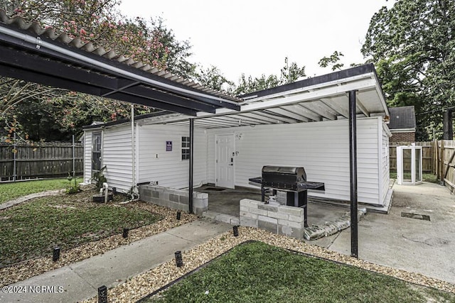 exterior space with a fenced backyard, an attached carport, and area for grilling