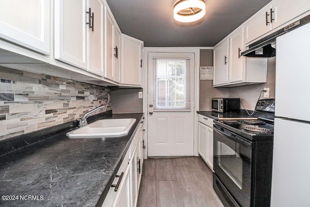 kitchen with white fridge, white cabinetry, sink, black / electric stove, and light hardwood / wood-style floors